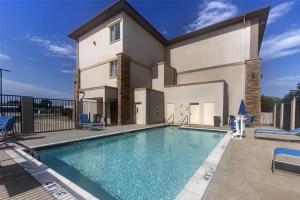 a swimming pool in front of a house at Best Western Plus Pauls Valley in Pauls Valley