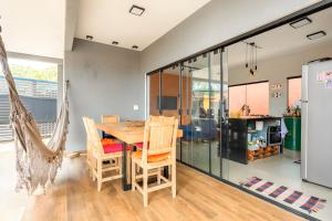a dining room with a wooden table and chairs at Casa com piscina, vista das montanhas, terraço, quintal in Pirenópolis +22 photos