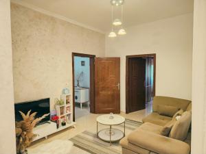 a living room with a couch and a table at White House Korçë Guesthouse in Maliq