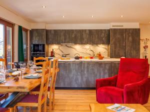 a kitchen and dining room with a table and red chairs at Apartment Praplan 21-22 by Interhome in Nendaz