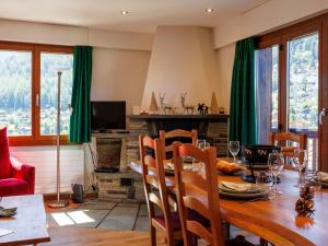 a dining room with a wooden table and green curtains at Apartment Praplan 21-22 by Interhome in Nendaz