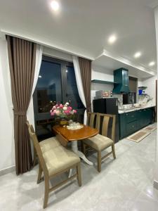 a kitchen with a wooden table and chairs and a kitchen with a counter at ISLA Homestay đảo Vũ Yên, Vinhomes Royal island in Hai Phong