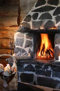 a stone fireplace with a fire in it at Holiday Home Alppimaja by Interhome in Pätiälä