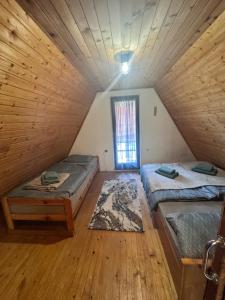 ホコ・ポホリェにあるChalet SS Pohorjeのベッド2台と窓が備わる屋根裏部屋です。