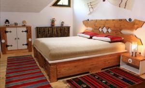 a bedroom with a large wooden bed with red pillows at Cabana Izvoranu in Izvoranu