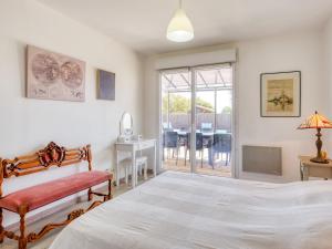 Un dormitorio con una cama y una mesa y sillas. en Villa Nael by Interhome, en Vendays-Montalivet