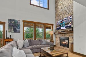 a living room with a couch and a fireplace at Prospector Pines Treetop Escape in Suncadia- Fairway View, BBQ, Outdoor Fireplace, Smart TVs, Hi-speed Wi-Fi in Cle Elum