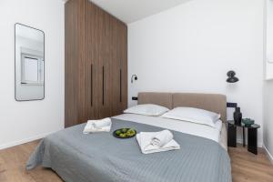 a bedroom with a bed with a bowl of fruit on it at Penthouse Andro, Omis in Omiš
