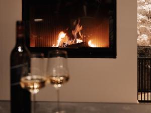 two glasses of wine in front of a fireplace at Holiday Home Haus am Kogl by Interhome in Wies