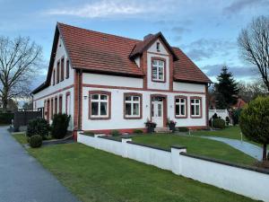 a white house with a red roof at Ferienwohnung, Apartment Schwertherz in Wulfsen