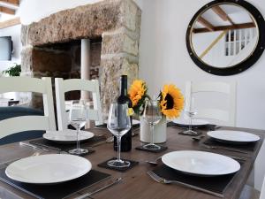 a wooden table with plates and glasses and a bottle of wine at Bryn Awel in Moelfre