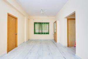 an empty room with a window and wooden doors at Hotel O Castle Inn Kondapur in Hyderabad