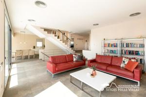a living room with red couches and a staircase at Cool & Modern Villa Giovanna with Air Conditioning, Private Pool & Sea Views in Sitges