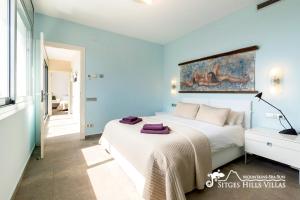 a bedroom with a bed and a painting on the wall at Cool & Modern Villa Giovanna with Air Conditioning, Private Pool & Sea Views in Sitges +34 photos