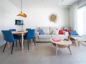 a living room with a couch and a table and chairs at Apartment L'agua Free Spa & Padel by Interhome in Torrox Costa