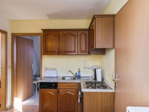 eine kleine Küche mit Holzschränken und einer Spüle in der Unterkunft Comfort in Central Ballenstedt in Ballenstedt