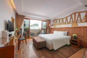a bedroom with a bed and a desk and a television at Hanoi Golden Holiday Hotel in Hanoi