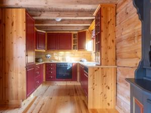 una cocina con paredes de madera y armarios de madera. en Holiday Home Koselia by Interhome, en Øyuvstad