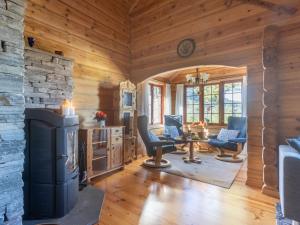 Una sala de estar con chimenea en una cabaña de troncos en Holiday Home Koselia by Interhome, en Øyuvstad