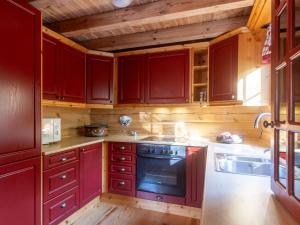 cocina con armarios rojos y fogones en Holiday Home Koselia by Interhome, en Øyuvstad 49 fotos más