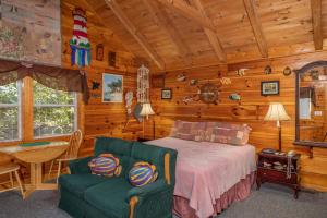 a bedroom with a bed and a chair in a cabin at Forever Yours by American Patriot Getaways in Cove Creek Cascades