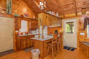 a kitchen with wooden walls and wooden floors and a white door at Forever Yours by American Patriot Getaways in Cove Creek Cascades