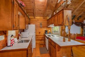 a kitchen with wooden cabinets and a white refrigerator at Forever Yours by American Patriot Getaways in Cove Creek Cascades