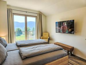 a bedroom with two beds and a large window at Chalet Ossiacher See Chalet 2 by Interhome in Bodensdorf