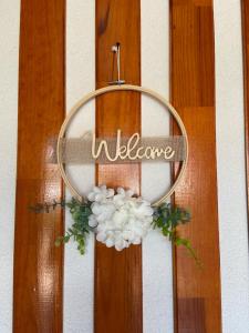 a welcome sign hanging on a door with flowers at Casa de Ferias Tranquilo in Bitarães