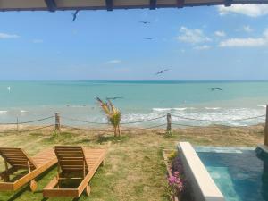 a couple of chairs sitting next to the ocean at Primaluna Romantica in La Punta de los Remedios