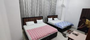 a man is cleaning a bedroom with two beds at jp hotel 