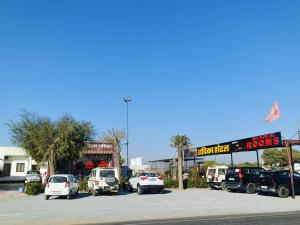 un estacionamiento con autos estacionados frente a una tienda en Radhika Hotel And Restaurant,  14 fotos más