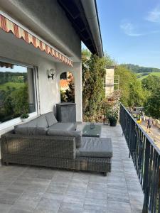 een terras met twee banken en een bank op een balkon bij REHBLICK Ferienwohnung in Trösel