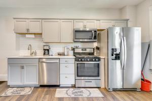 a kitchen with stainless steel appliances and white cabinets at Shop and Dine Central Stroudsburg Townhome! in Stroudsburg