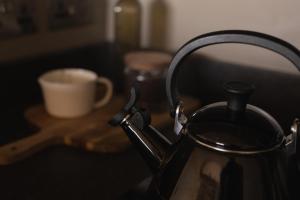 a black tea kettle sitting on a table with a cup at 'SLOE at Daniels in Gloucestershire
