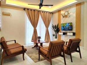un soggiorno con sedie, tavolo e TV di GRANDE MAISON HOMES 2 A'Famosa Golf view Near WATERPARK l UITM l HONDA l Netflix l Self Check in a Kampong Alor Gajah