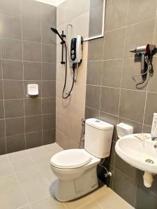 bagno con servizi igienici e telefono appeso al muro di GRANDE MAISON HOMES 2 A'Famosa Golf view Near WATERPARK l UITM l HONDA l Netflix l Self Check in a Kampong Alor Gajah