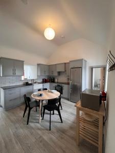a kitchen with a table and chairs in a room at Bunowen Cottage, Louisburgh in Louisburgh