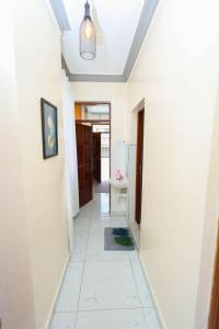 a hallway with white walls and a white tile floor at The Loft in Mombasa