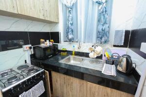 a small kitchen with a stove and a sink at The Loft in Mombasa