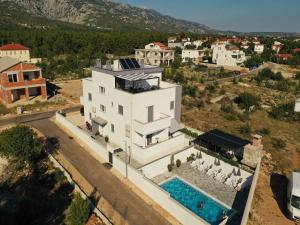 une vue aérienne d'une maison avec piscine dans l'établissement Apartments in Starigrad-Paklenica 41220, à Starigrad-Paklenica