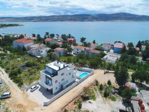 une vue aérienne d'une maison à côté d'un plan d'eau dans l'établissement Apartments in Starigrad-Paklenica 41220, à Starigrad-Paklenica