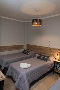 2 camas en una habitación de hotel con luz en Tu Lugar Alojamientos Temporarios, en Salta