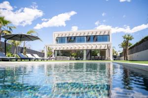 a house with a swimming pool in front of a house at Villa Praya in Valencia in Bétera