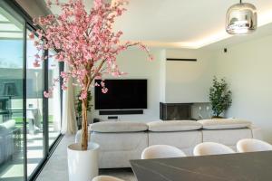 a living room with a couch and a table with a tree at Villa Praya in Valencia in Bétera