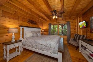 Un dormitorio con una cama en una cabaña de troncos en Fox Ridge by American Patriot Getaways, en McCookville