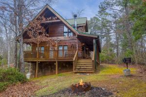 una cabaña de madera en el bosque con una hoguera en Fox Ridge by American Patriot Getaways, en McCookville