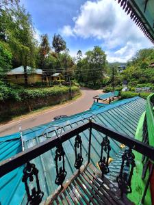 a balcony with a blue roof and a road at Casalinda munnar by Foxinroom in Devikolam +35 photos