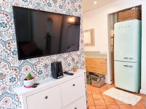 a living room with a flat screen tv on a wall at EXIGEHOME-Large studio with terrace 15 min Paris-La Défense in Suresnes