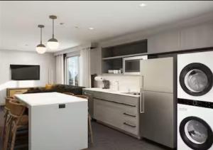 a kitchen with a refrigerator and a sink at Homewood Suites By Hilton Austin Airport in Austin
